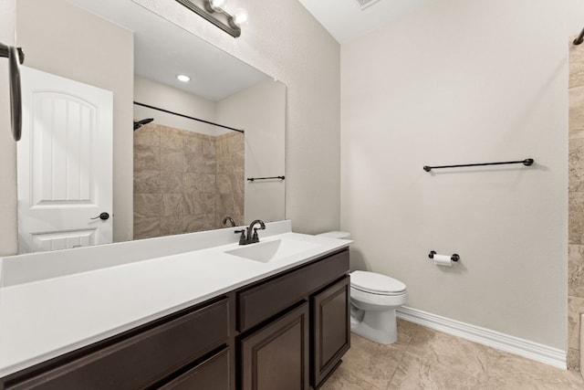 bathroom with toilet, baseboards, vanity, and a shower