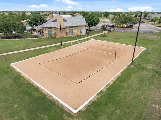 view of community with volleyball court and a lawn