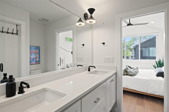 909 Mansell Ave Unit 2, Austin, TX 78702 - bathroom featuring double vanity, toilet, a ceiling fan, connected bathroom, and wood finished floors