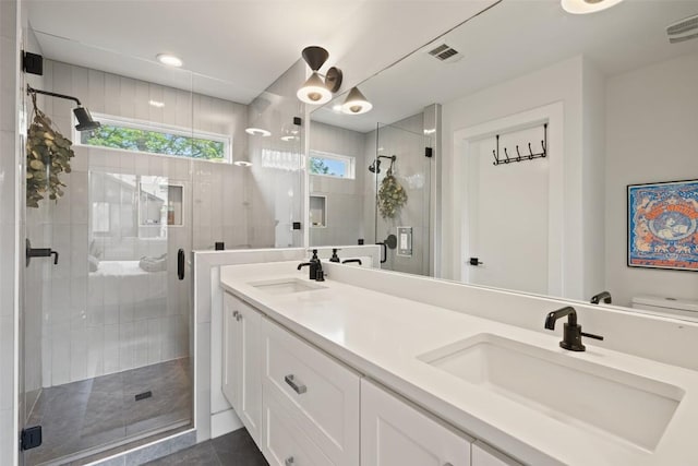 909 Mansell Ave Unit 2, Austin, TX 78702 - bathroom featuring a stall shower, double vanity, toilet, and tile patterned flooring