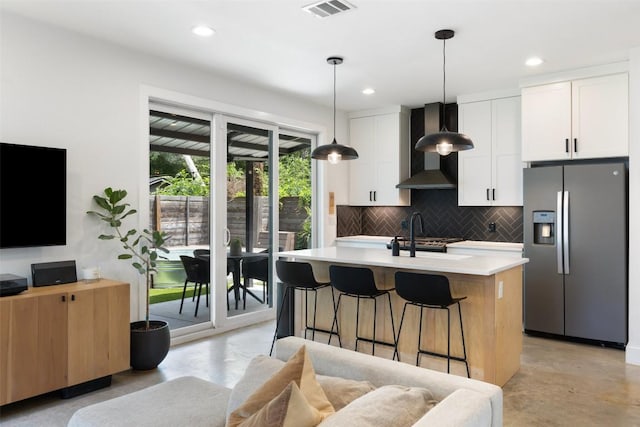 909 Mansell Ave Unit 2, Austin, TX 78702 - kitchen featuring stainless steel fridge with ice dispenser, wall chimney exhaust hood, concrete flooring, a sink, and decorative backsplash