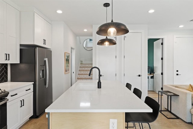 909 Mansell Ave Unit 2, Austin, TX 78702 - kitchen with a sink, a breakfast bar, white cabinets, decorative backsplash, and recessed lighting