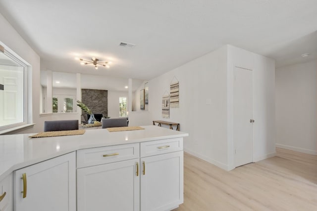 4011 Eskew Dr, Austin, TX 78749 - kitchen with light wood-style flooring, white cabinets, open floor plan, and light countertops