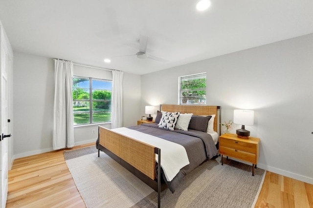 bedroom with multiple windows, light wood-style flooring, baseboards, and recessed lighting