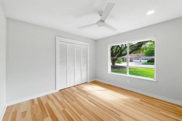 unfurnished bedroom featuring a closet, wood finished floors, baseboards, a ceiling fan, and recessed lighting