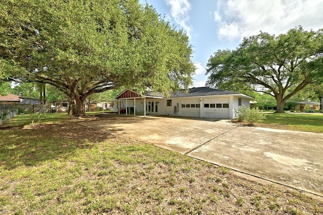 ranch-style house featuring a garage, concrete driveway, and a front yard