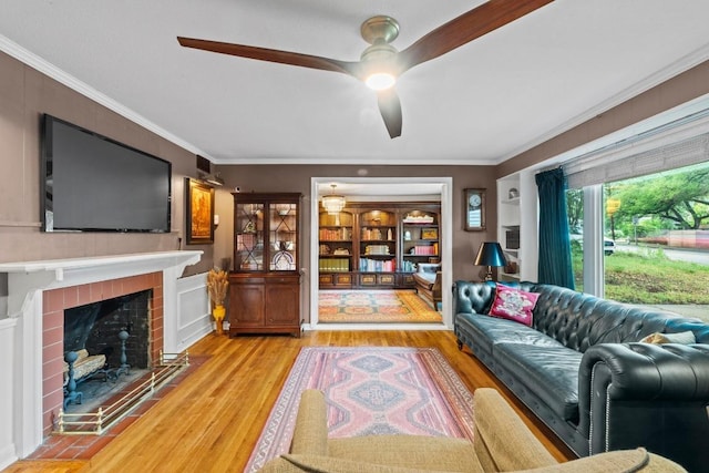 2621 W 45th St, Austin, TX 78731 - living area with a ceiling fan, wood finished floors, a tile fireplace, and crown molding