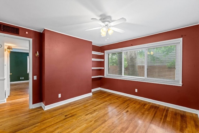 2621 W 45th St, Austin, TX 78731 - empty room featuring wood finished floors, ceiling fan, baseboards, and built in shelves