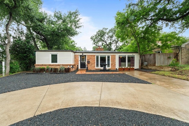 2621 W 45th St, Austin, TX 78731 - view of front of house with brick siding, driveway, and a chimney