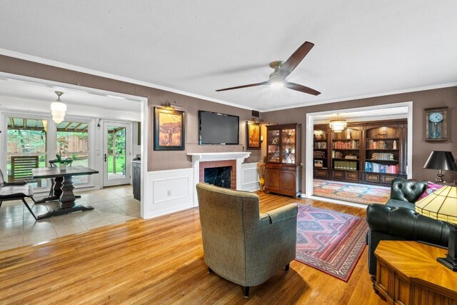 2621 W 45th St, Austin, TX 78731 - living room featuring a fireplace, crown molding, a ceiling fan, and wood finished floors
