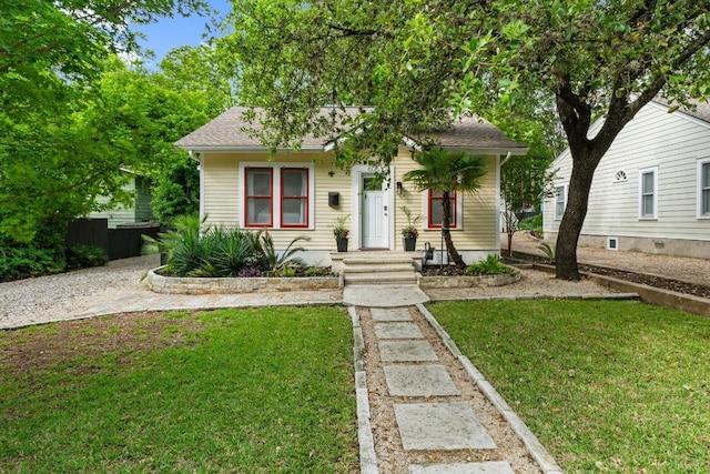 bungalow-style home featuring a front lawn and a shingled roof