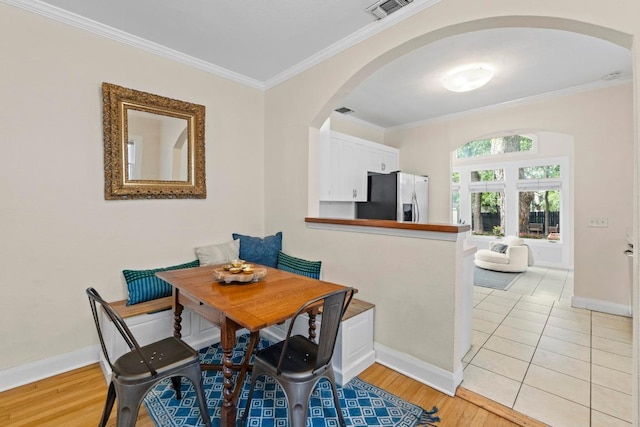 605 E 43rd St, Austin, TX 78751 - dining space with arched walkways, crown molding, and light wood-style floors