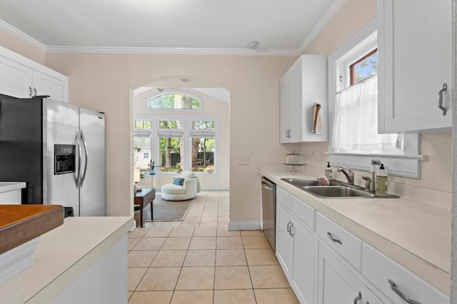 605 E 43rd St, Austin, TX 78751 - kitchen featuring appliances with stainless steel finishes, ornamental molding, white cabinets, light countertops, and light tile patterned flooring