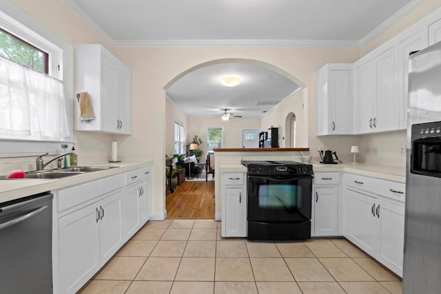 605 E 43rd St, Austin, TX 78751 - kitchen featuring appliances with stainless steel finishes, arched walkways, ceiling fan, white cabinetry, and light countertops