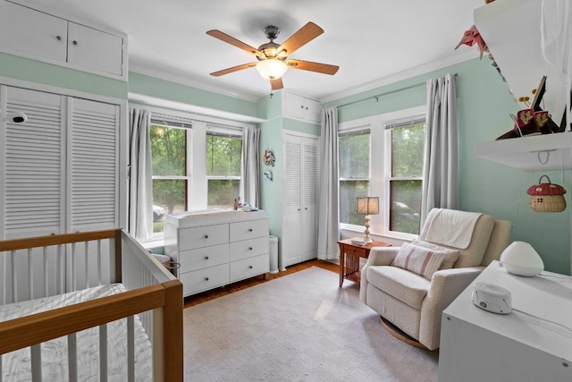 605 E 43rd St, Austin, TX 78751 - bedroom featuring multiple windows, wood finished floors, a nursery area, and a ceiling fan