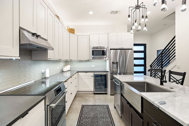 1310 Choquette Dr Unit B, Austin, TX 78757 - kitchen with stainless steel appliances, wine cooler, under cabinet range hood, tasteful backsplash, and a sink