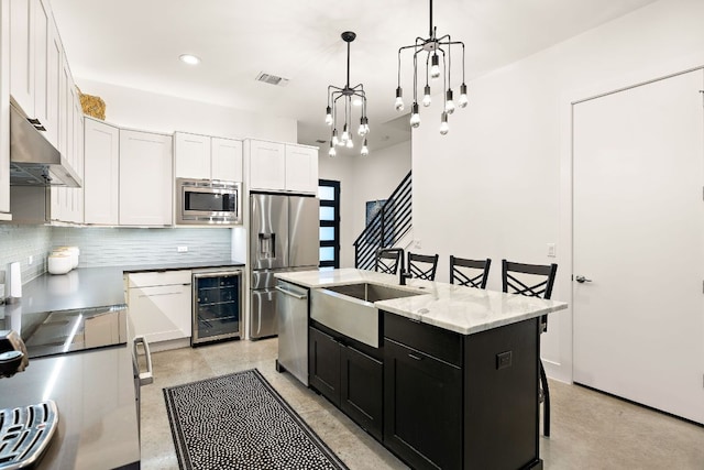 1310 Choquette Dr Unit B, Austin, TX 78757 - kitchen with wine cooler, extractor fan, appliances with stainless steel finishes, a sink, and dark cabinetry