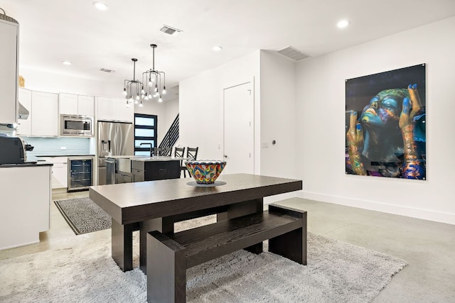 1310 Choquette Dr Unit B, Austin, TX 78757 - dining room featuring beverage cooler, a chandelier, concrete floors, baseboards, and recessed lighting