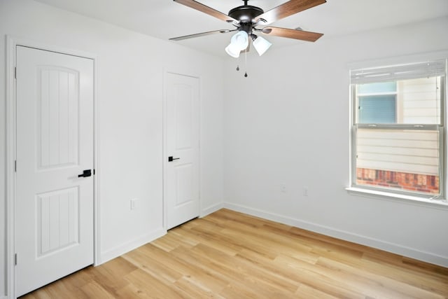 unfurnished bedroom with light wood-type flooring, baseboards, and a ceiling fan