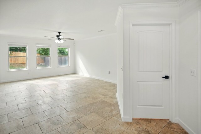 unfurnished room featuring ceiling fan, baseboards, crown molding, and light stone finish floors