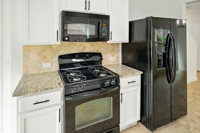 kitchen with black appliances, light stone countertops, and white cabinets
