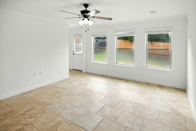 spare room featuring a ceiling fan, crown molding, and baseboards