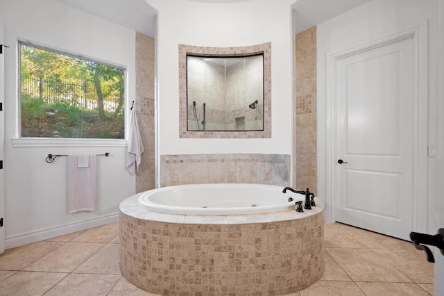 full bathroom featuring a whirlpool tub, a tile shower, and tile patterned floors