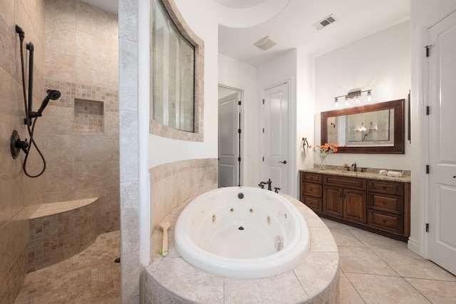 bathroom with a walk in shower, a tub with jets, vanity, and tile patterned flooring