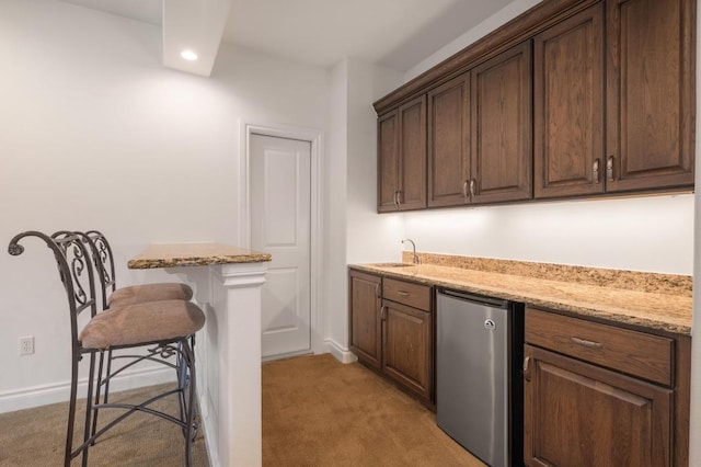 indoor wet bar with refrigerator, light carpet, recessed lighting, and baseboards