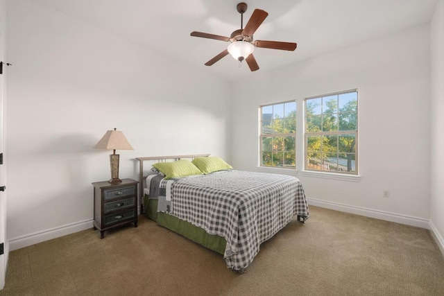 carpeted bedroom with baseboards and a ceiling fan