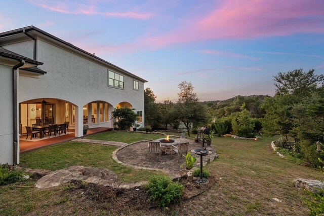 4105 Michael Neill Dr, Austin, TX 78730 - yard at dusk with a fire pit, a patio, a yard, and french doors
