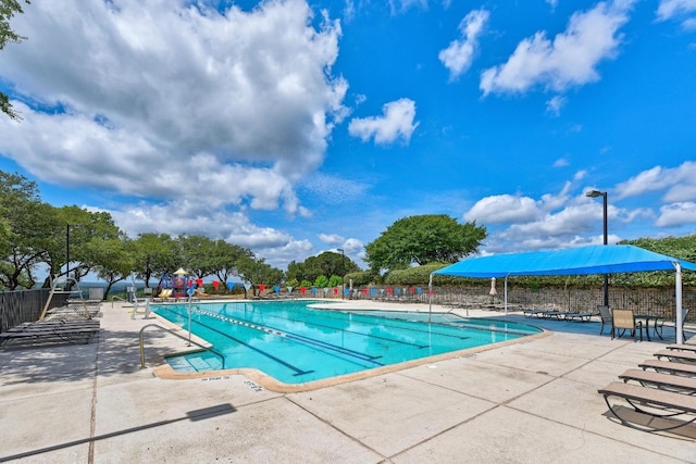 community pool with fence and a patio area