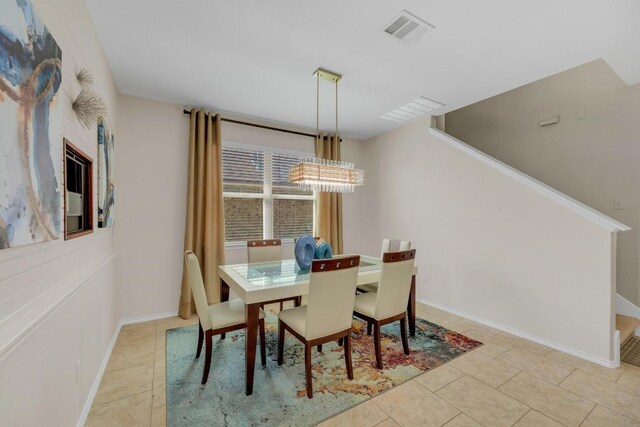 3624 Anchor Bay Dr, Pflugerville, TX 78660 - dining space featuring light tile patterned flooring, a chandelier, stairway, and baseboards