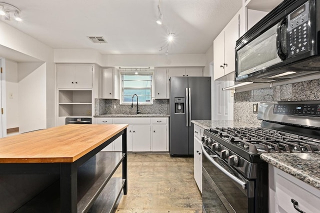 7004 Priscilla Dr, Austin, TX 78752 - kitchen featuring appliances with stainless steel finishes, butcher block counters, a sink, and backsplash