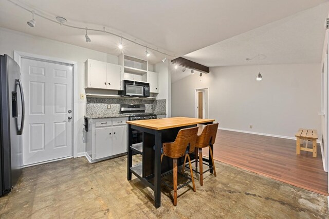 7004 Priscilla Dr, Austin, TX 78752 - kitchen featuring stainless steel appliances, white cabinets, decorative backsplash, rail lighting, and wooden counters