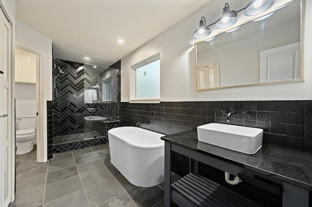 7004 Priscilla Dr, Austin, TX 78752 - full bath with tile walls, a shower stall, a freestanding bath, toilet, and tile patterned flooring