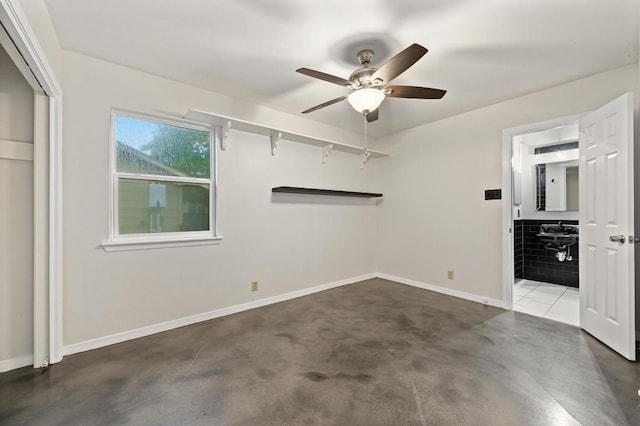 7004 Priscilla Dr, Austin, TX 78752 - unfurnished bedroom with concrete floors, baseboards, a ceiling fan, and connected bathroom