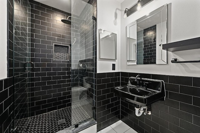 7004 Priscilla Dr, Austin, TX 78752 - full bathroom featuring a shower stall, tile walls, wainscoting, and a sink