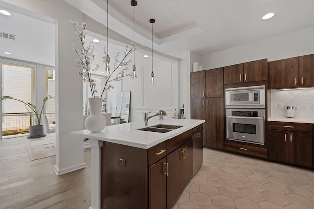 1500 Summit St Unit 5, Austin, TX 78741 - kitchen with stainless steel appliances, a sink, light countertops, a kitchen island with sink, and recessed lighting