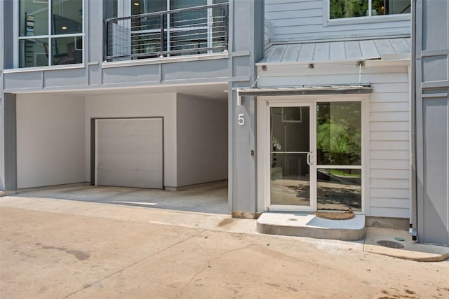 1500 Summit St Unit 5, Austin, TX 78741 - view of exterior entry with a balcony, a standing seam roof, an attached garage, metal roof, and a carport