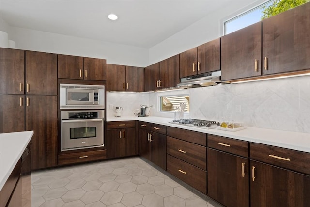 1500 Summit St Unit 5, Austin, TX 78741 - kitchen with appliances with stainless steel finishes, under cabinet range hood, light countertops, and backsplash