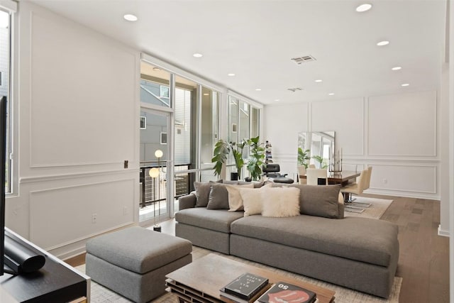 1500 Summit St Unit 5, Austin, TX 78741 - living area featuring a decorative wall, wood finished floors, a wall of windows, and recessed lighting
