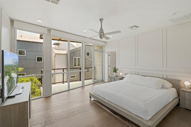 1500 Summit St Unit 5, Austin, TX 78741 - bedroom with a decorative wall, wood finished floors, access to exterior, ceiling fan, and recessed lighting