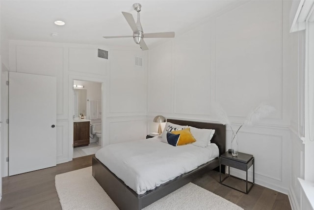 1500 Summit St Unit 5, Austin, TX 78741 - bedroom featuring a decorative wall, wood finished floors, connected bathroom, and a ceiling fan
