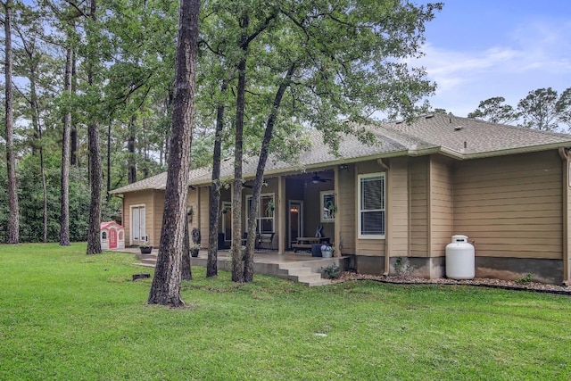 115 Loblolly Ln, Bastrop, TX 78602 - back of property featuring a ceiling fan, a yard, and a patio area