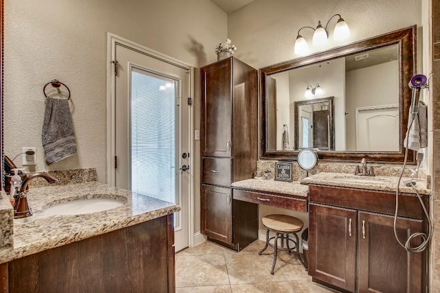115 Loblolly Ln, Bastrop, TX 78602 - full bathroom with two vanities, a textured wall, and tile patterned floors