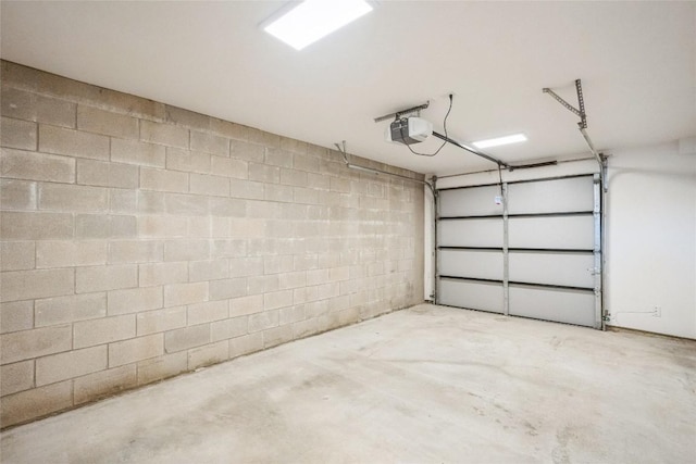 700 Denson Dr Unit 1101, Austin, TX 78752 - garage featuring a garage door opener and concrete block wall