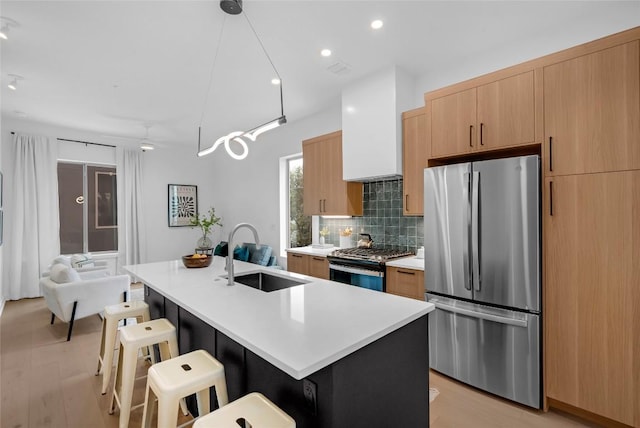 700 Denson Dr Unit 1101, Austin, TX 78752 - kitchen with appliances with stainless steel finishes, a sink, tasteful backsplash, a center island with sink, and a breakfast bar area