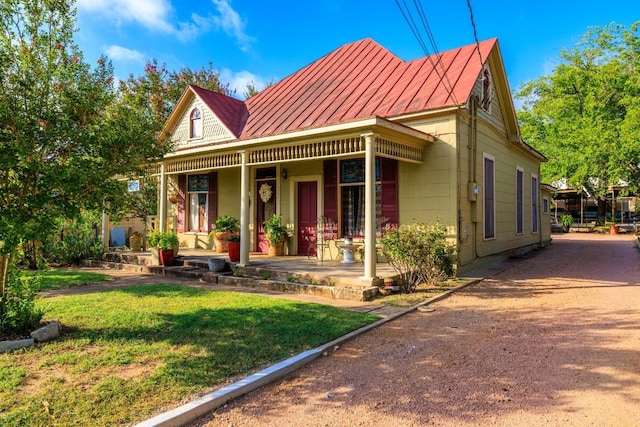 303 Austin St, Fredericksburg, TX 78624 - view of front facade featuring covered porch, a front yard, metal roof, and a standing seam roof