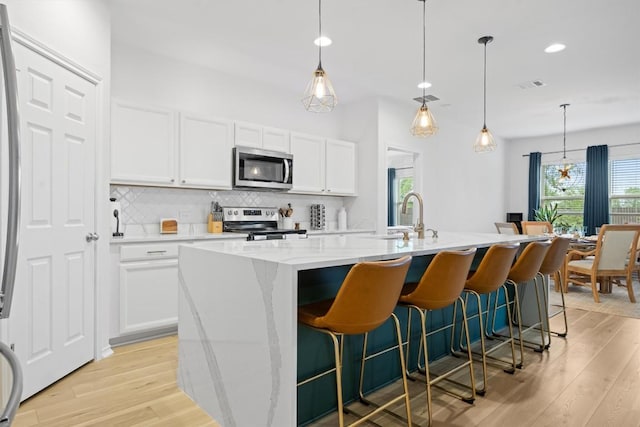6404 Routenburn St, Austin, TX 78754 - kitchen with appliances with stainless steel finishes, plenty of natural light, decorative backsplash, light wood-style floors, and recessed lighting